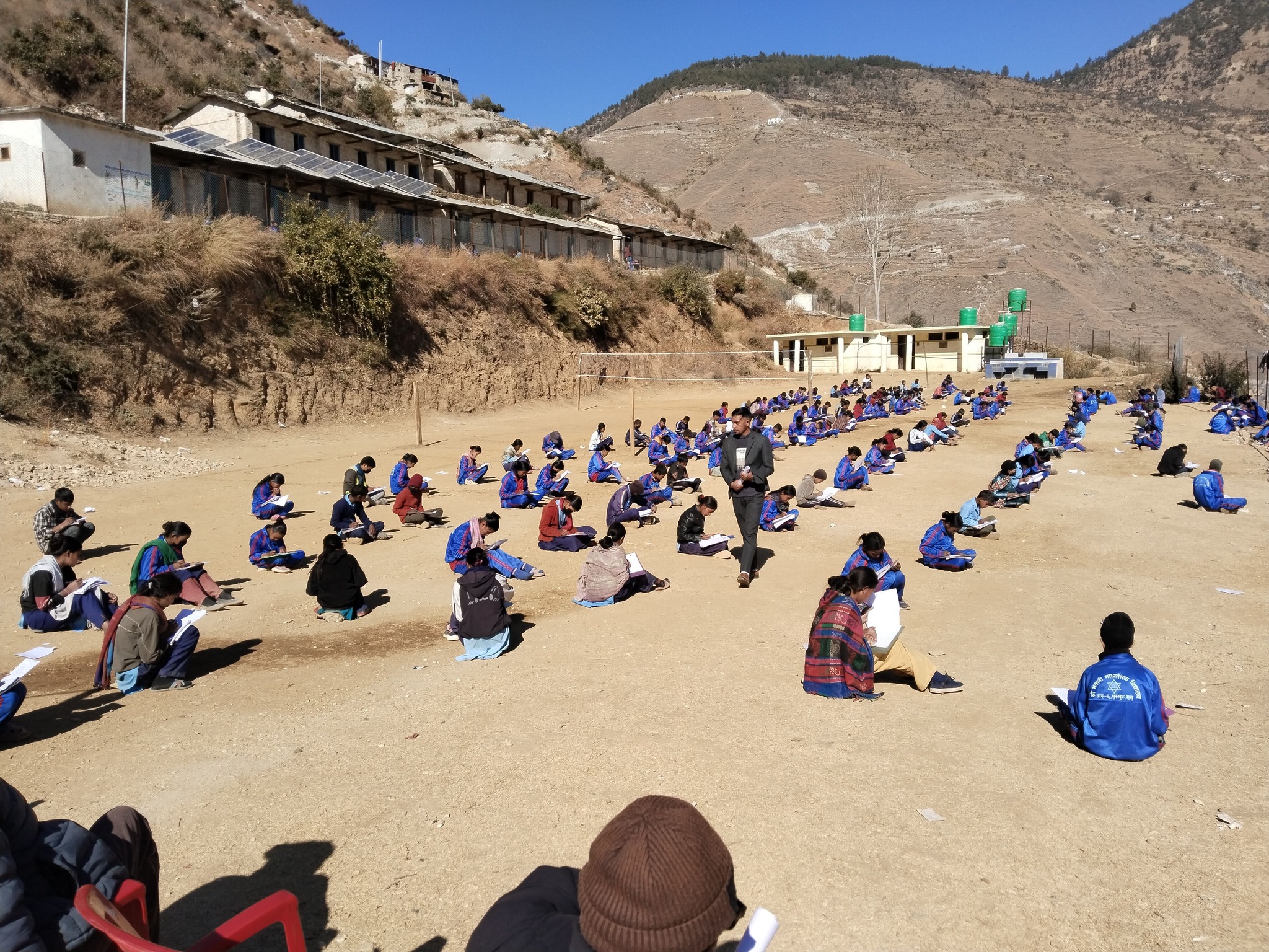 खुल्ला चौरमा घाम ताप्दै परीक्षा  दिदै  विद्यार्थी